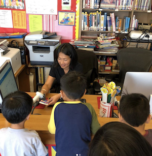 kids crowded around a school library checkout desk