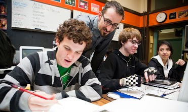 Teacher looking over student's sholder to help