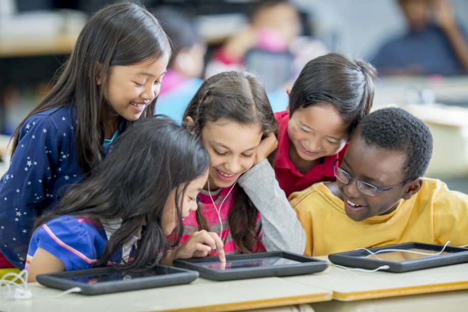 A small group of students viewing a tablet