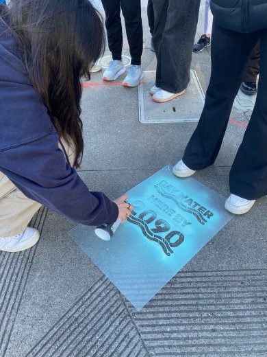 A student on a science field trip to the Embaracadero marks where water will be in 2090.