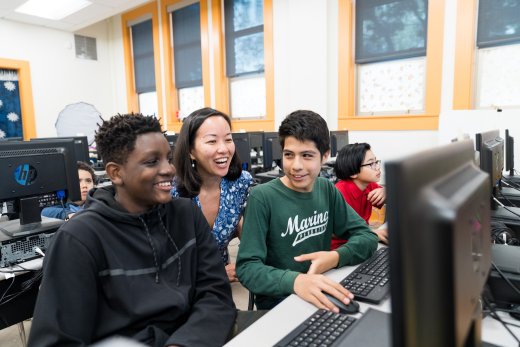 Teens and a teacher gathered around a computer