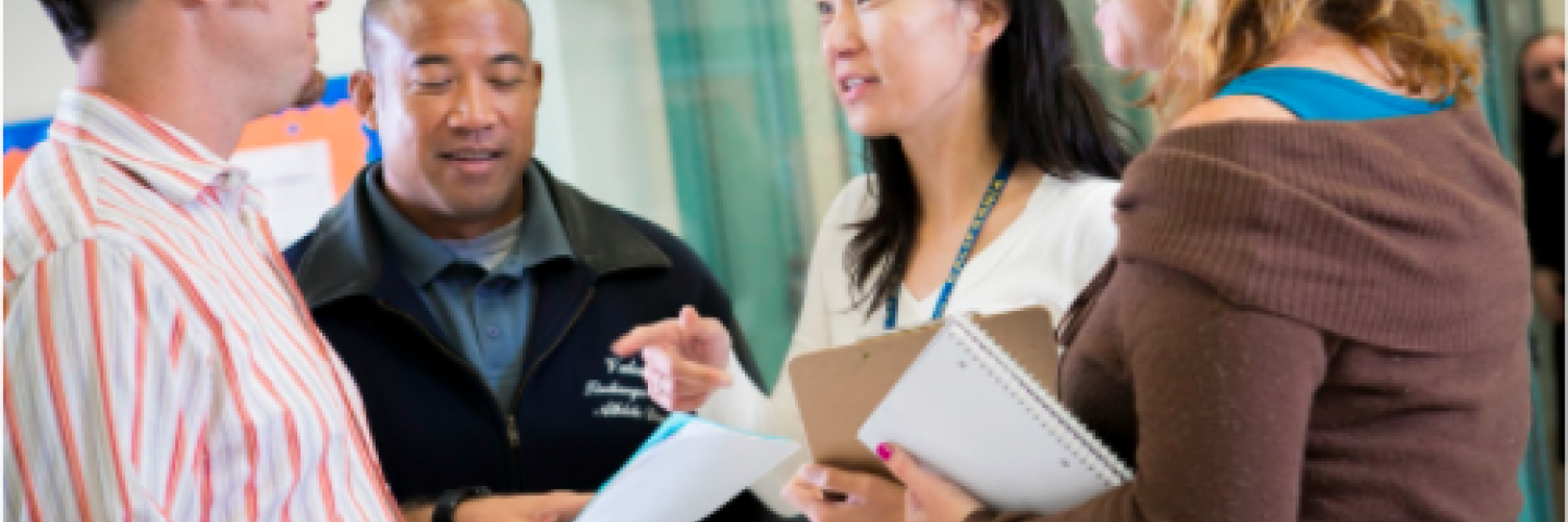 Four teachers meeting in hallway