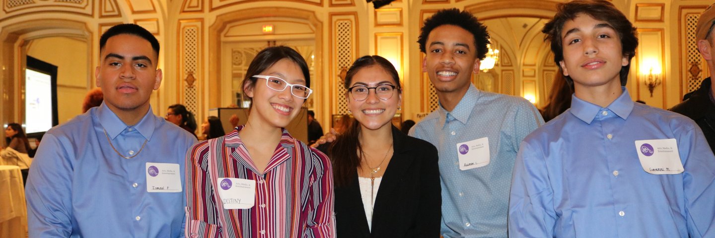 Students stand in front of an audience at past Career Pathways Showcases. 