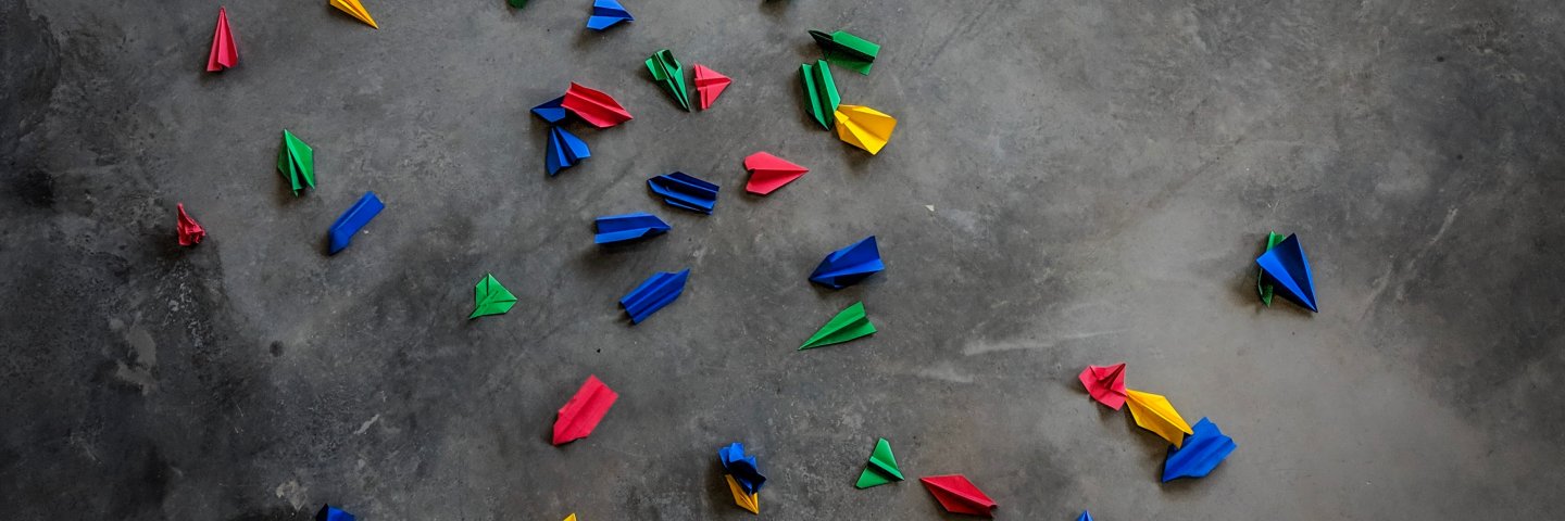 Lots of little paper airplanes scattered on the floor
