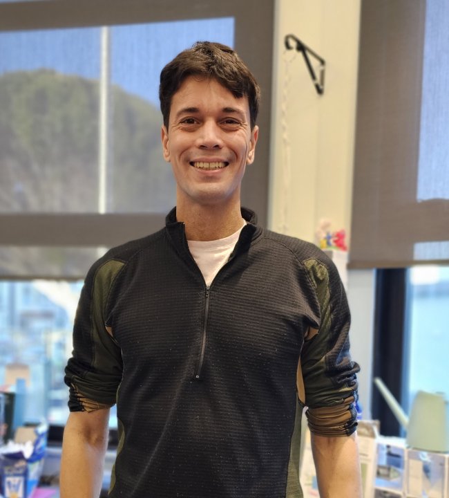 Mr. Mark smiling while standing in the office