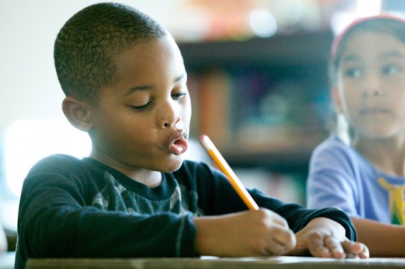 Black boy writing at a desk