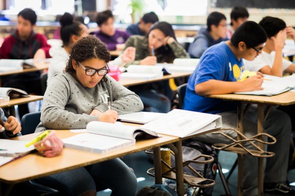 Middle school student at desk studying book