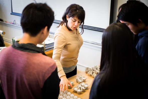 Teacher looking at high school student work