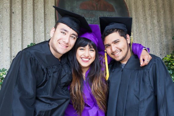 Three high school students in graduation caps and gowns