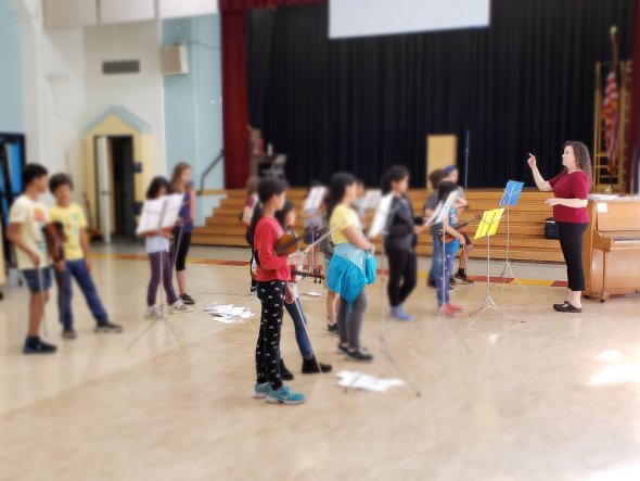 Children listening to violin teacher