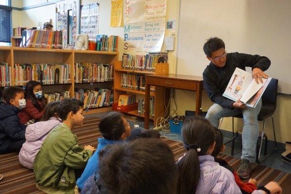 parent reading to group of students 