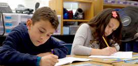 two students write in their math journal