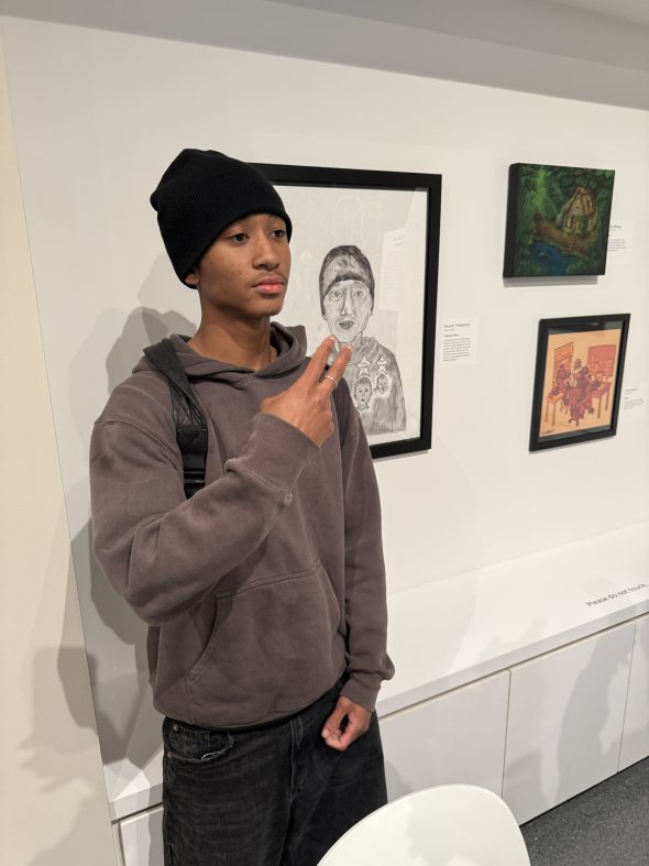 Student posting in front of his artwork