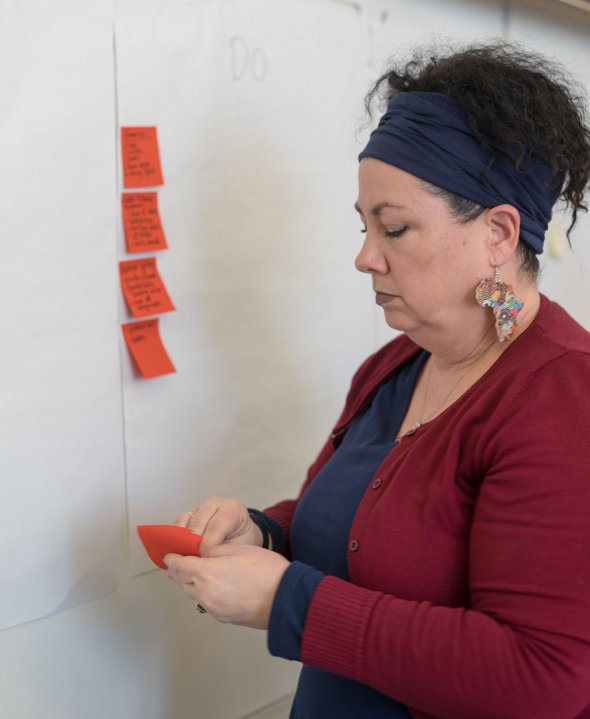 Teacher reading post it with student quote. 