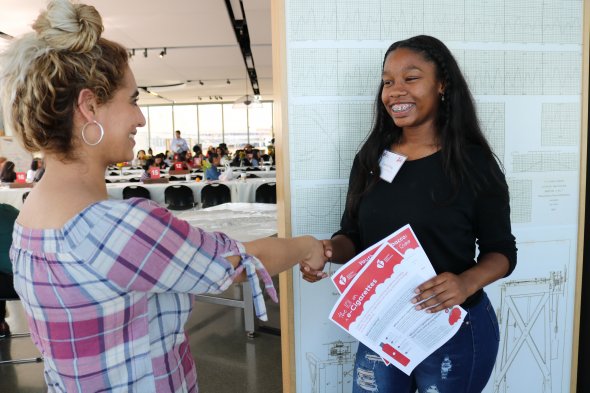 Student shakes hands with an industry partner at a mock interview event.
