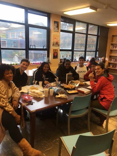 Students and staff sitting at a table in the library 