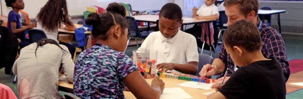 Students working with a teacher on an assignment