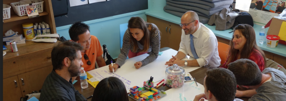 Parents and teachers gathered around a whiteboard