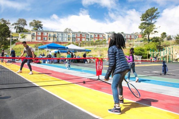 Kid playing tennis at Malcolm X's Shared Schoolyard