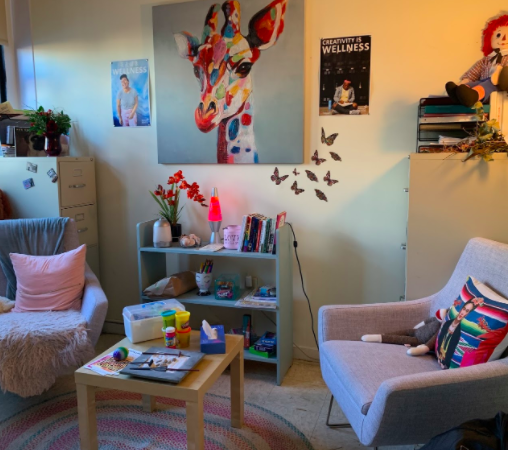 Room with two small couches, coffee table, art decor and ambient lighting
