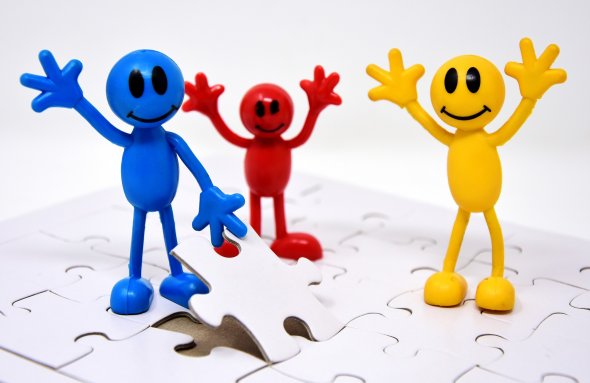Icon of Teamwork with puzzle pieces and three plastic figures