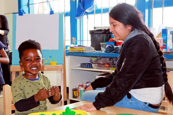Boy and teacher playing with clay