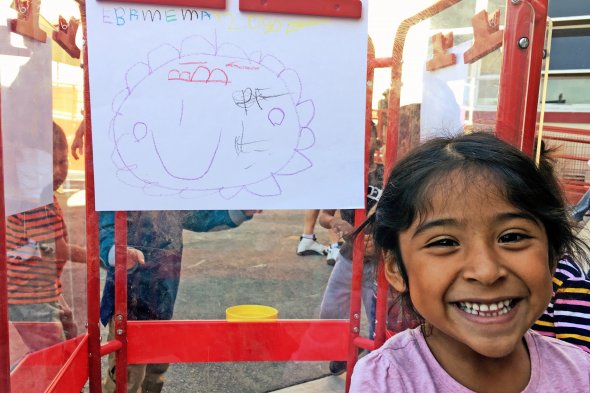 Girl smiling at camera with artwork behind her