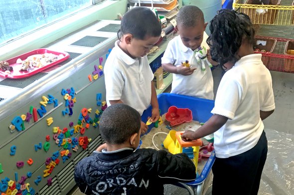 Children playing with sand in classroom