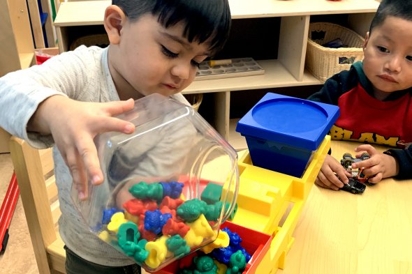 Boy pouring toys onto a scale