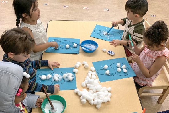Group of children making arts and crafts at table