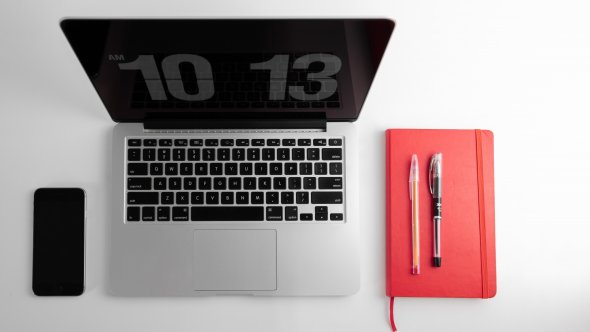 Desktop with phone, laptop, and notebook