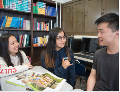 three students talking using hand gestures in academic conversation