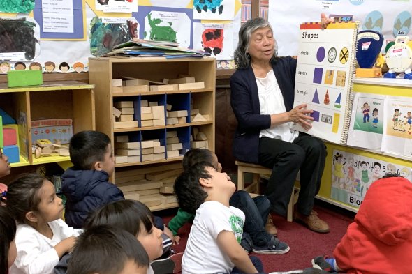 Teacher showing shapes and colors to classroom of children
