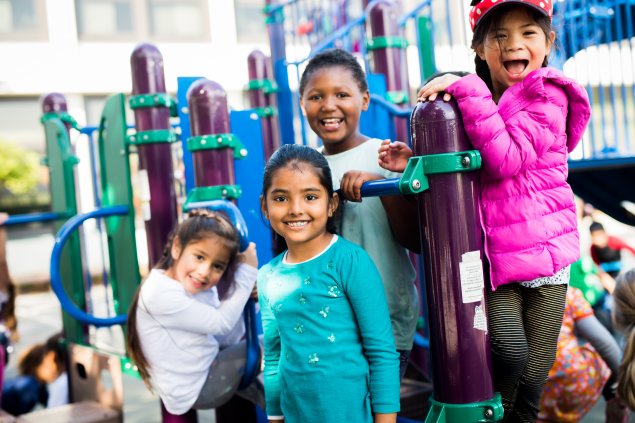 Four children smiling on a playground