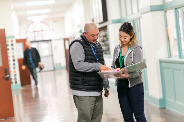 Two teachers standing in hallway