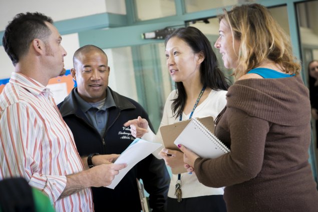 Four teachers meeting in hallway