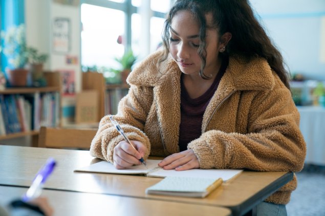 A student fills out a job paper application. 
