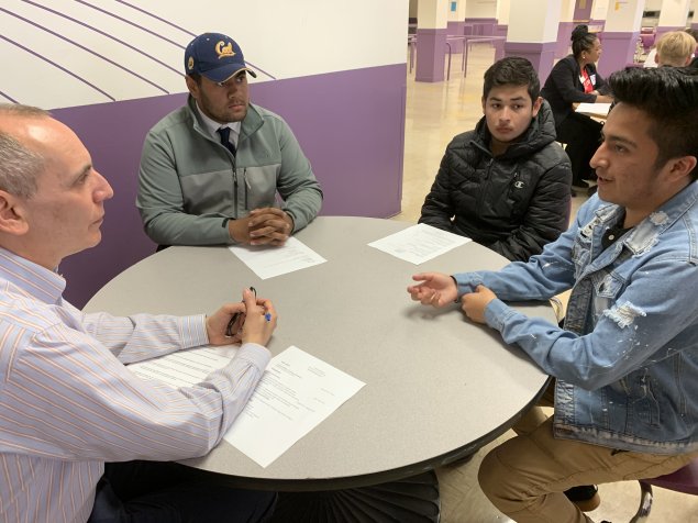 Students speaking with mentor.