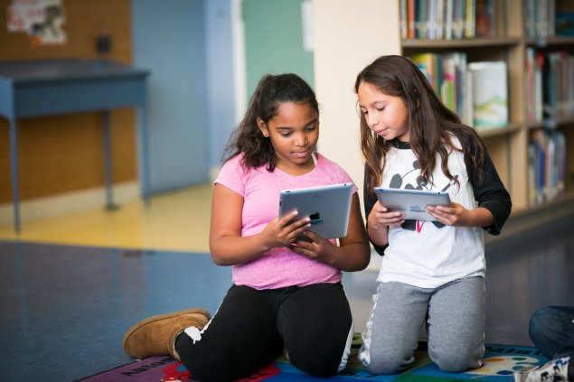 Two girls looking at their ipads
