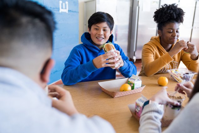 Two students eat school lunch