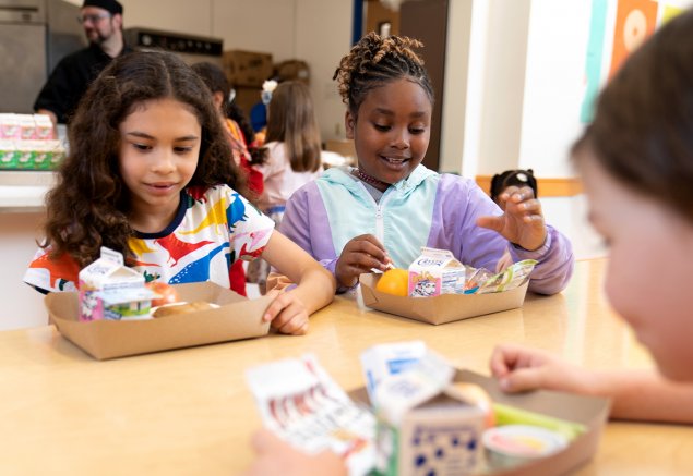 Two young students eat school lunch