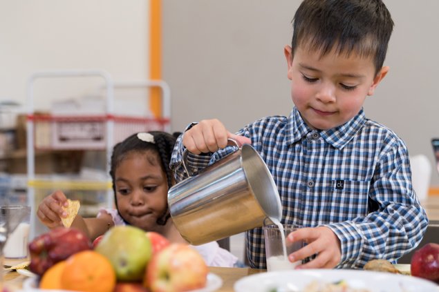 Student pours milk for lunch
