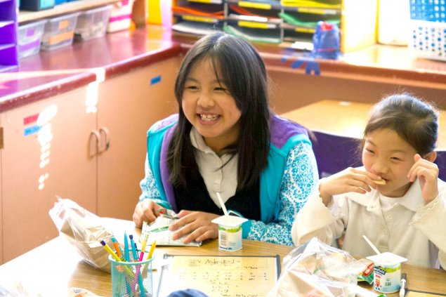 Two students eat breakfast in the classroom