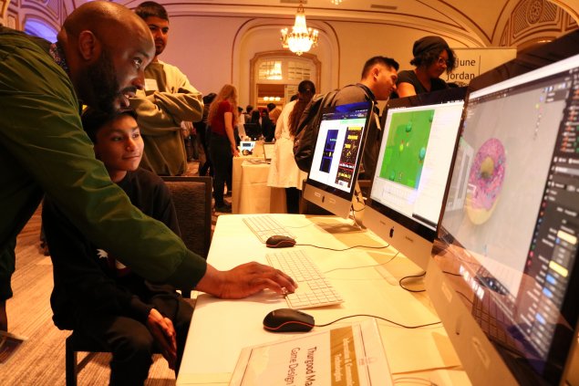 Mentor reviews student work at a school event.