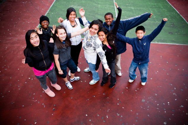 Students standing outdoors with their arms outstretched