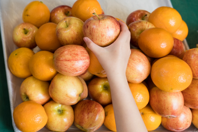 student reaches for apple