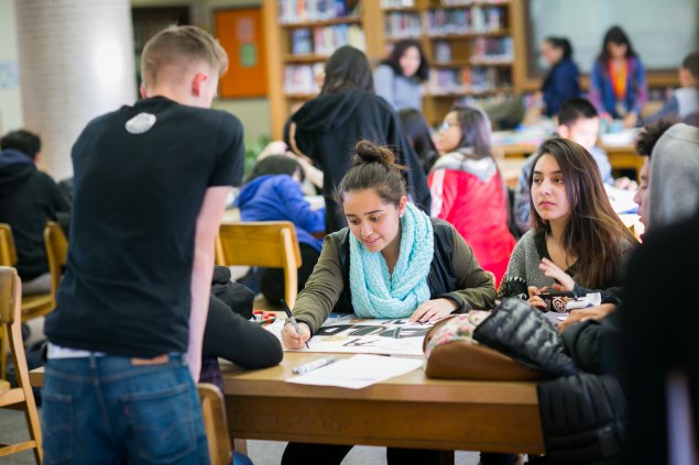 Students sitting at a table doing work together