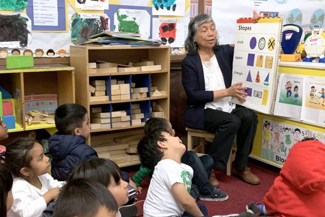 Teacher showing shapes and colors to classroom of children